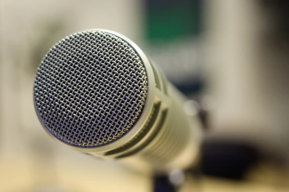 A radio host at a microphone in a small studio, a company radio show streamed on DCAST