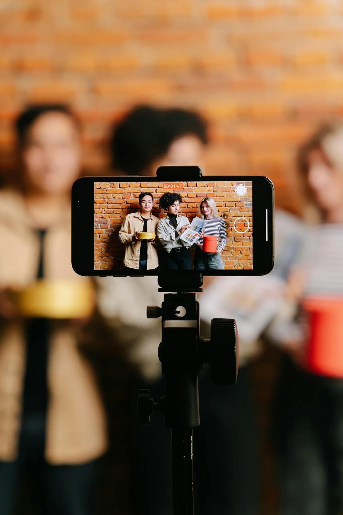 Smartphone on a tripod filming a live stream of three presenters