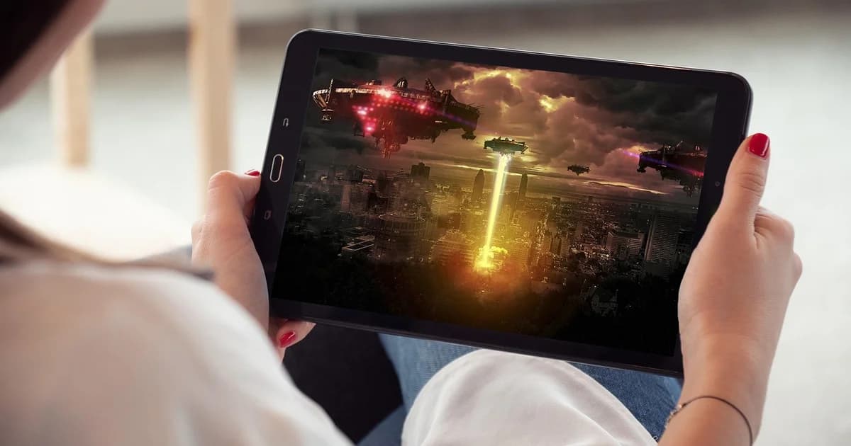 A viewer holding a tablet and watching an on-demand film